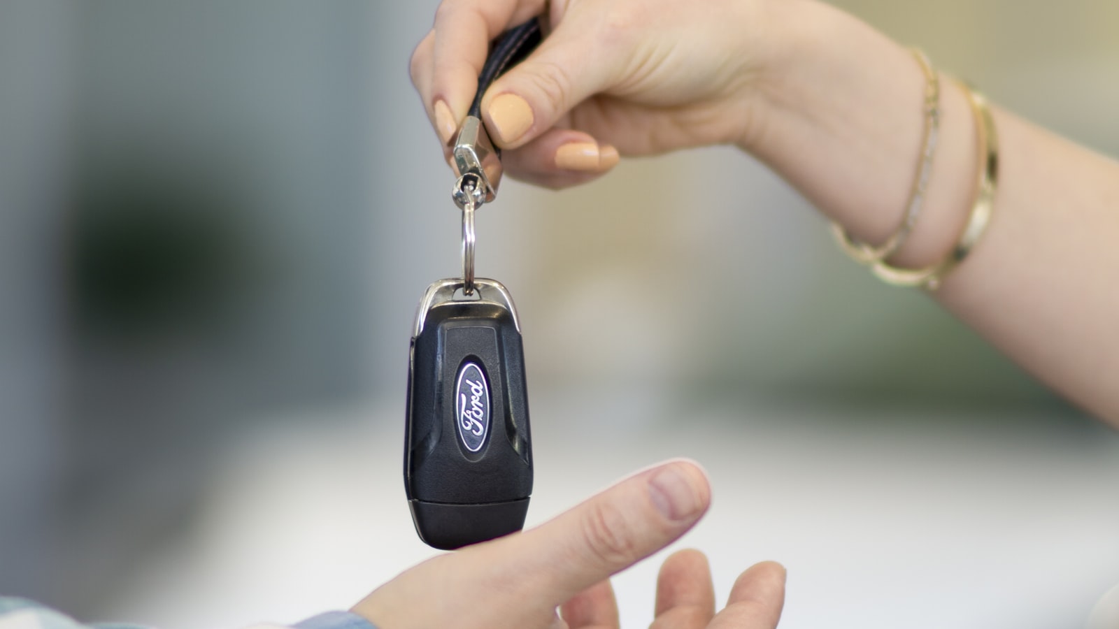Un hôte remet la clé de la voiture à un client, sans dépôt de garantie